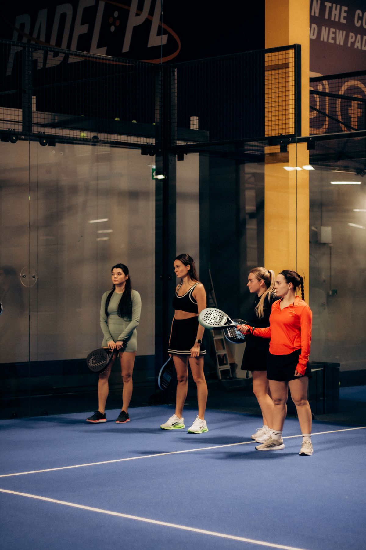 Quatre joueuses de padel réunies sur un terrain indoor