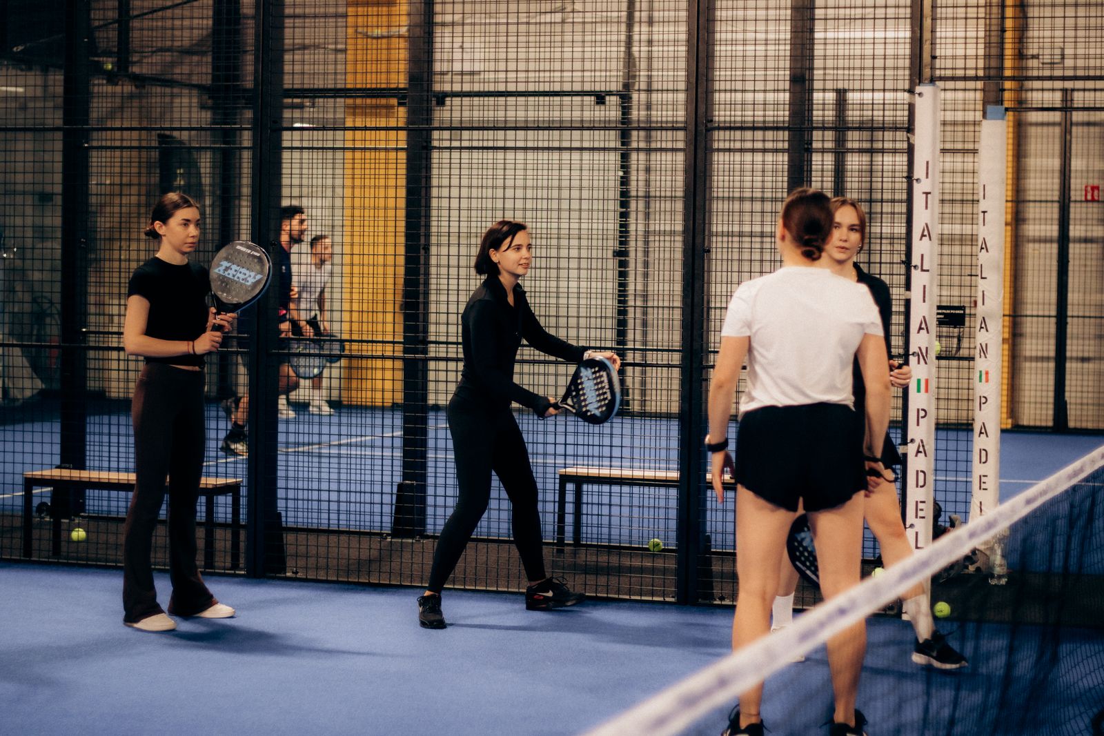 Quatre joueurs de padel sur un terrain moderne